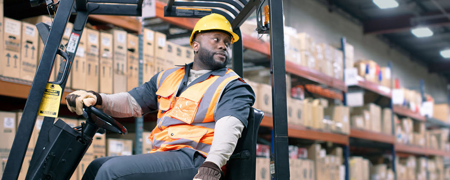 Forklift operator working in warehouse