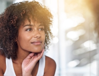 Young African American woman with sunlight on her face.